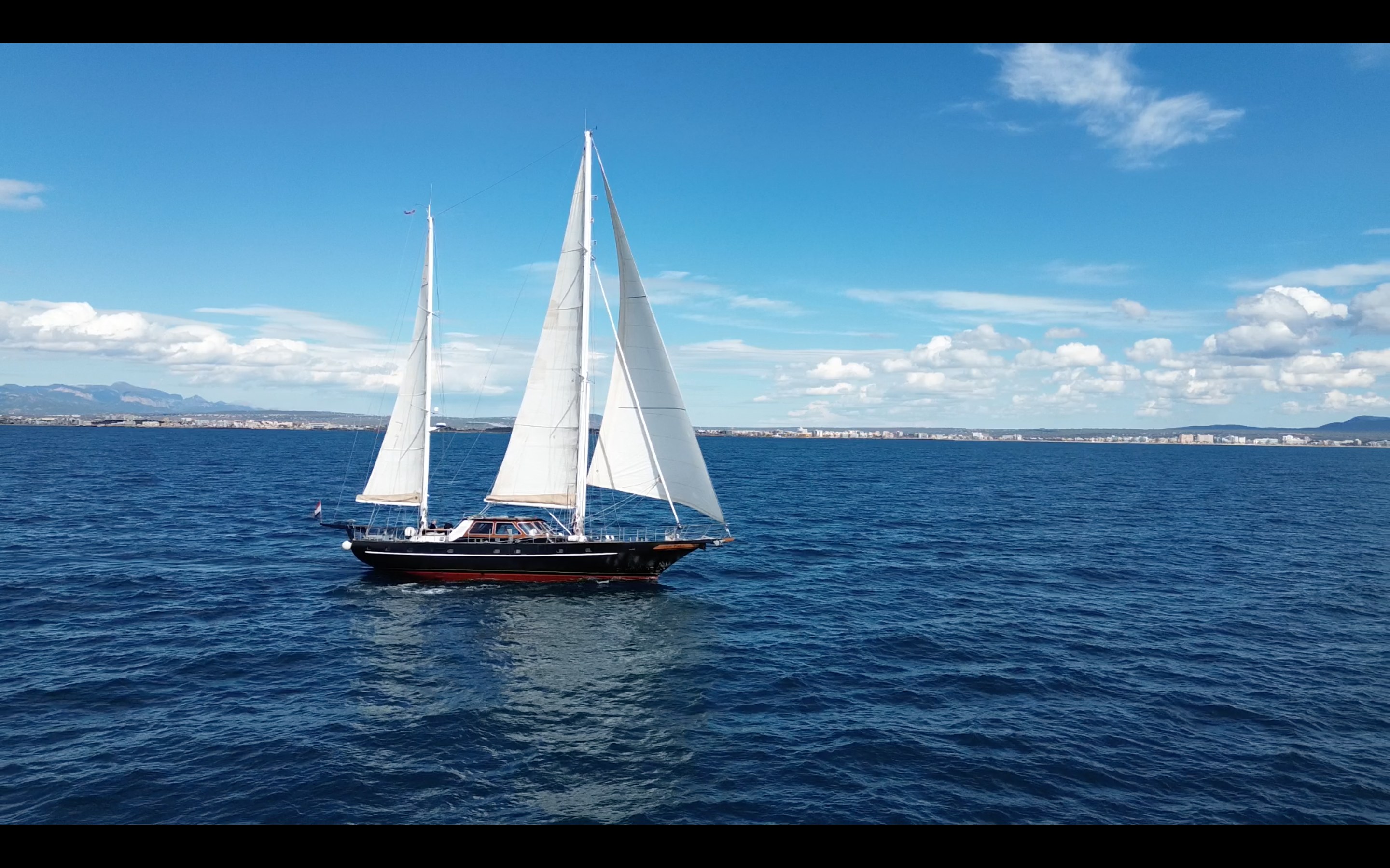SV Iron Monkey under full sail on blue water off Mallorca